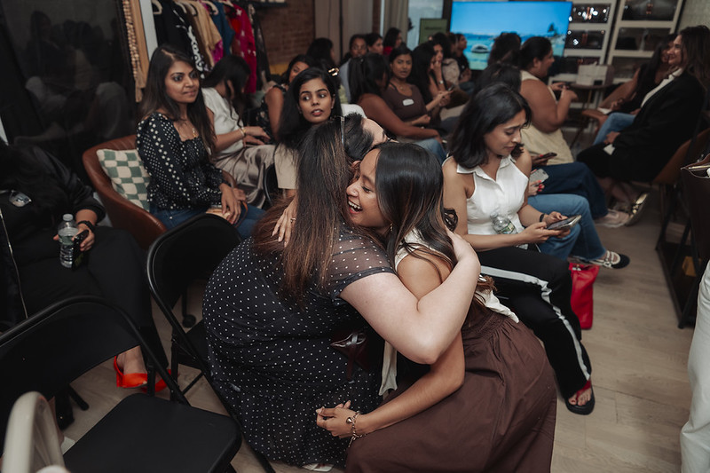 Two founders embracing after a pitch — community supporting community