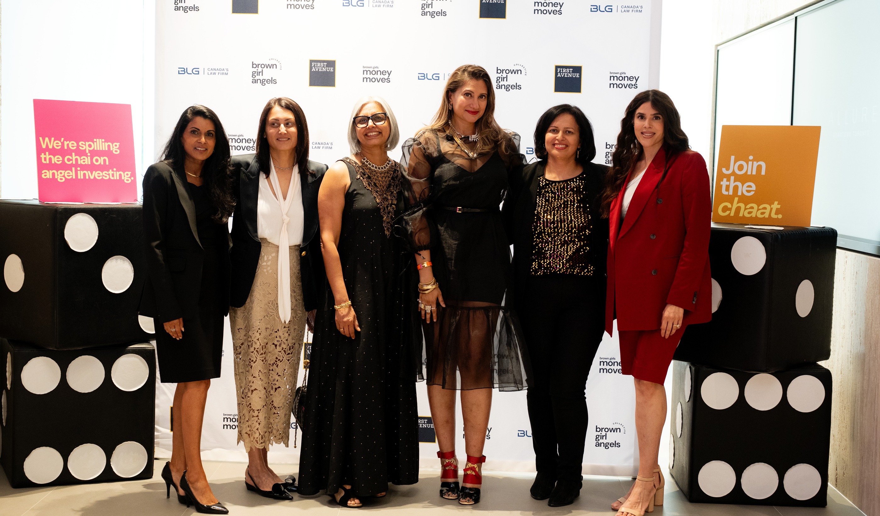 Six women at the Brown Girl Angels Poker Power night, gathered at the press wall — money, power, table.